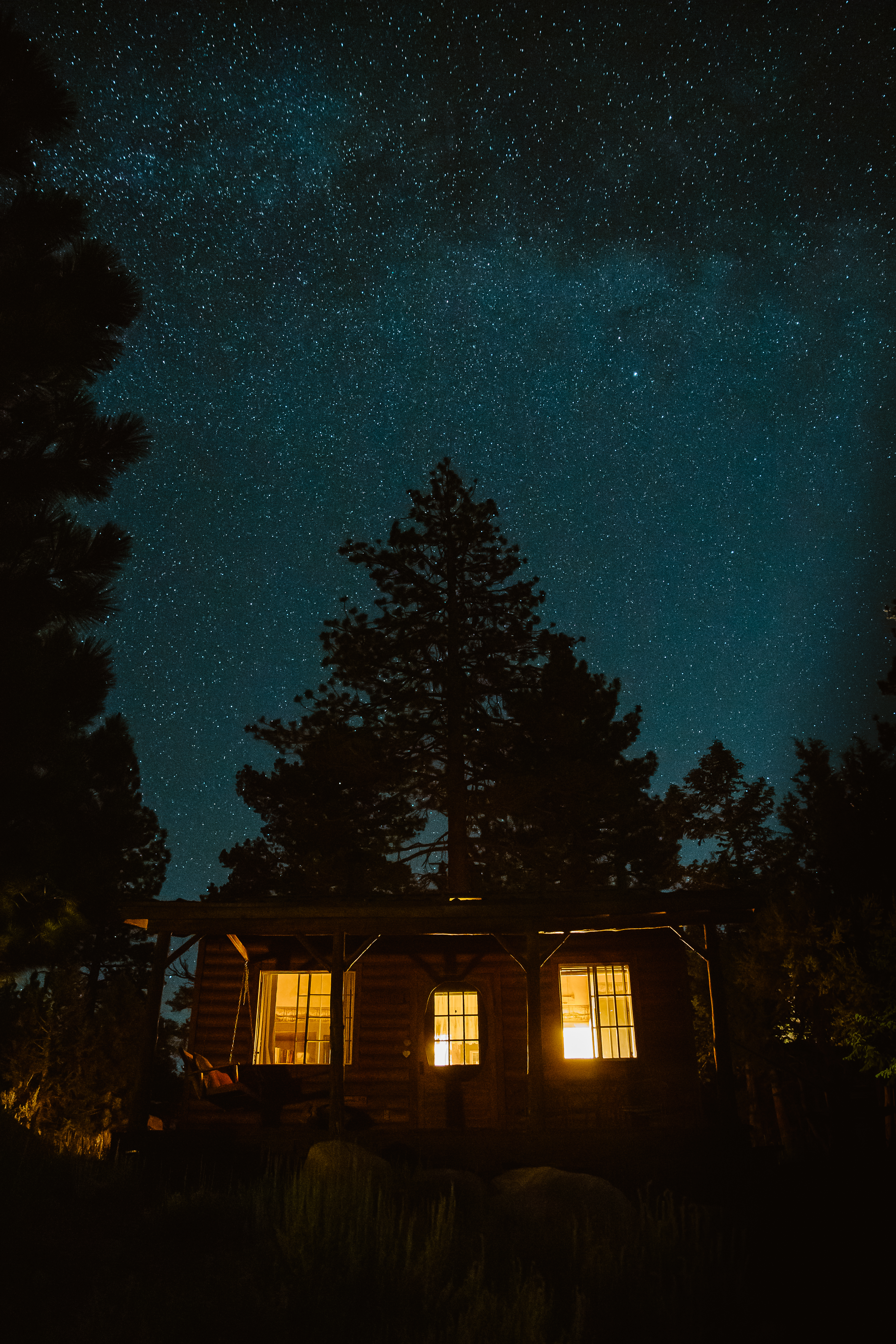 Cabin in the woods with night sky and stars