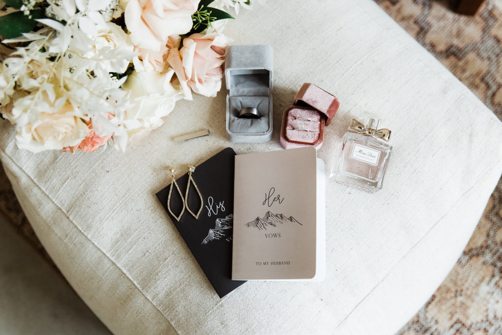 Vow books, wedding rings, perfume and flowers for an elopement day