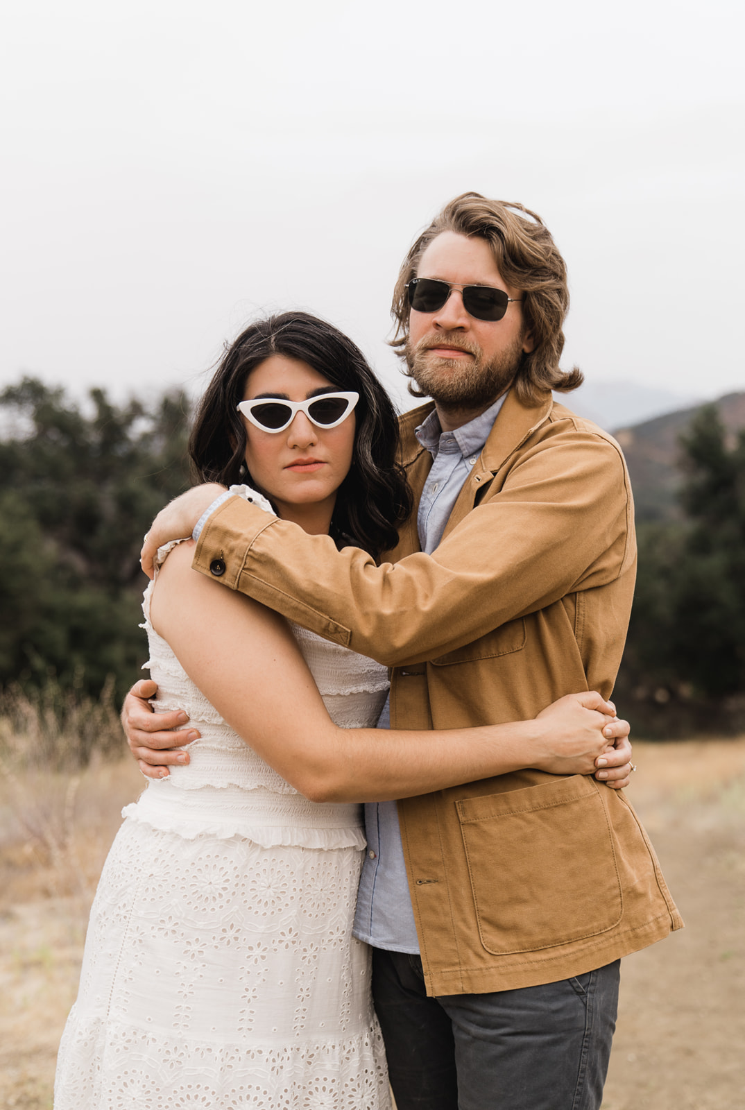 Woman and man hug with sunglasses on
