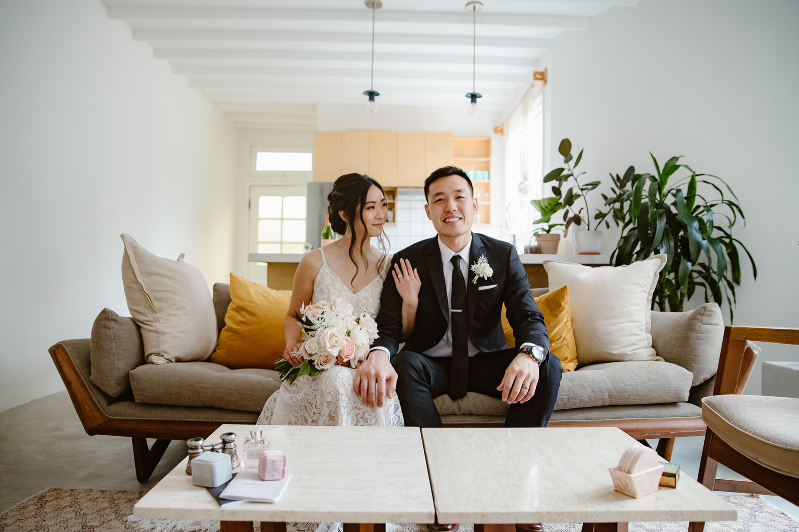 Bride looks at groom while sitting on couch